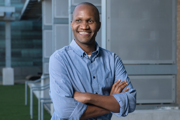 A man standing with folded arms posing for a picture